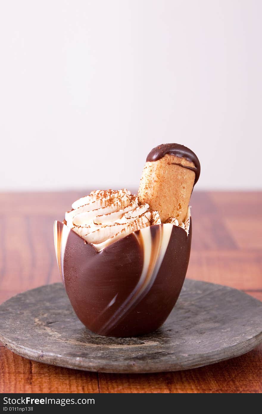 Rich, decadent Tiramisu served in a chocolate cup. Sprinkled with fine cinnamon powder and topped with a lady finger cookie. Rich, decadent Tiramisu served in a chocolate cup. Sprinkled with fine cinnamon powder and topped with a lady finger cookie.