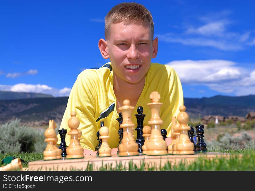 Teenager play chess on sunny day.