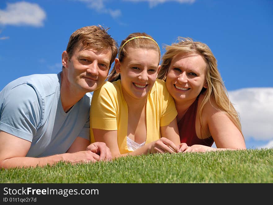 Daughter with parents on grass area. Daughter with parents on grass area