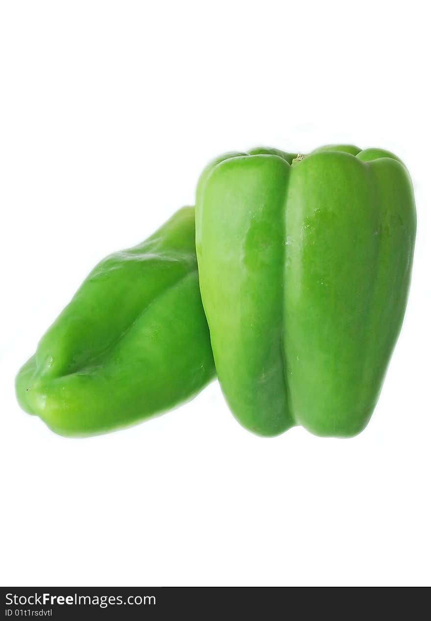 Two fresh green peppers over white