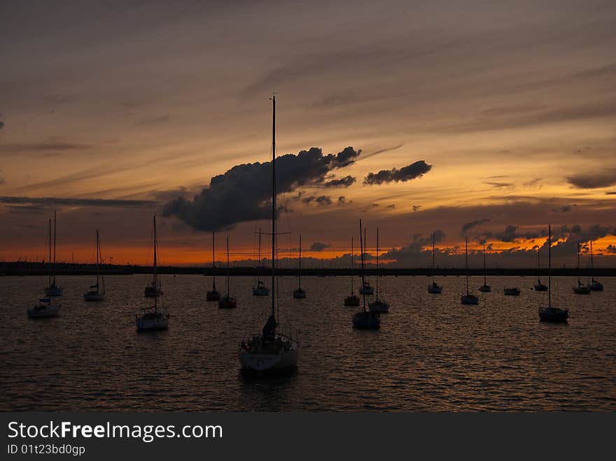 Port with docked yachts at golden sunset