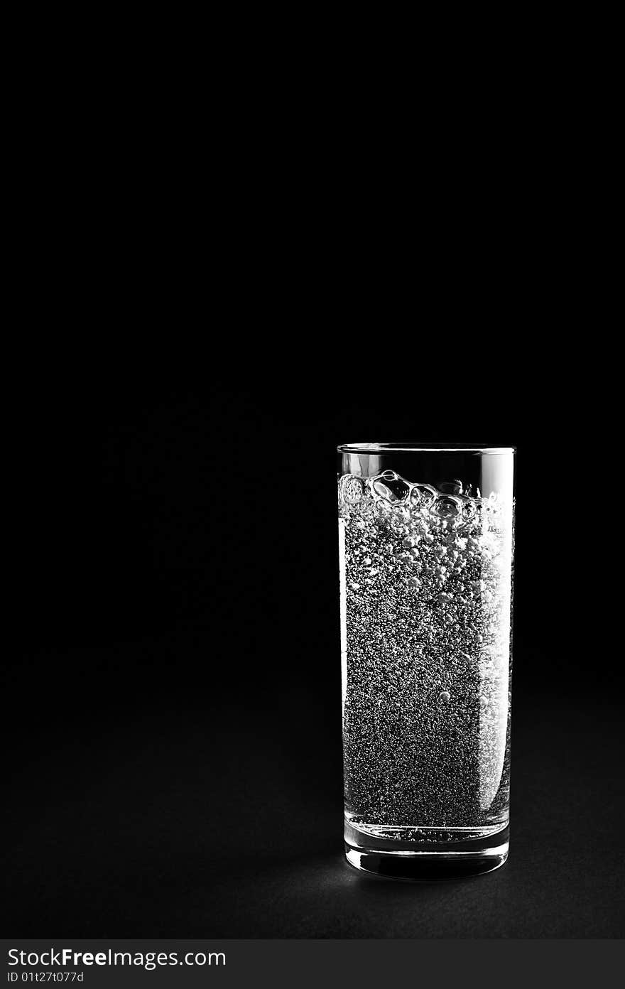 Glass of mineral water is isolated against a black background