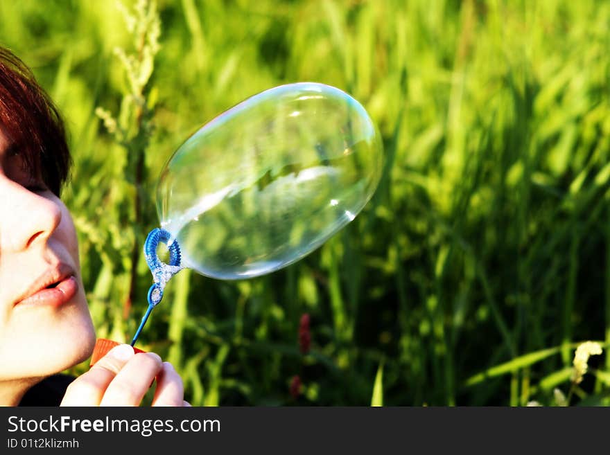 A woman is blowing a  bubble