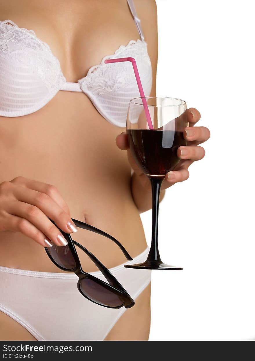 The young woman in underwear on a white background with glasses and wine in a hand. The young woman in underwear on a white background with glasses and wine in a hand