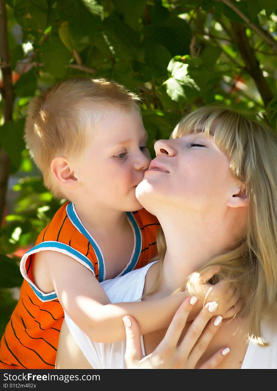 Woman and young boy outdoors embracing and smiling. Woman and young boy outdoors embracing and smiling