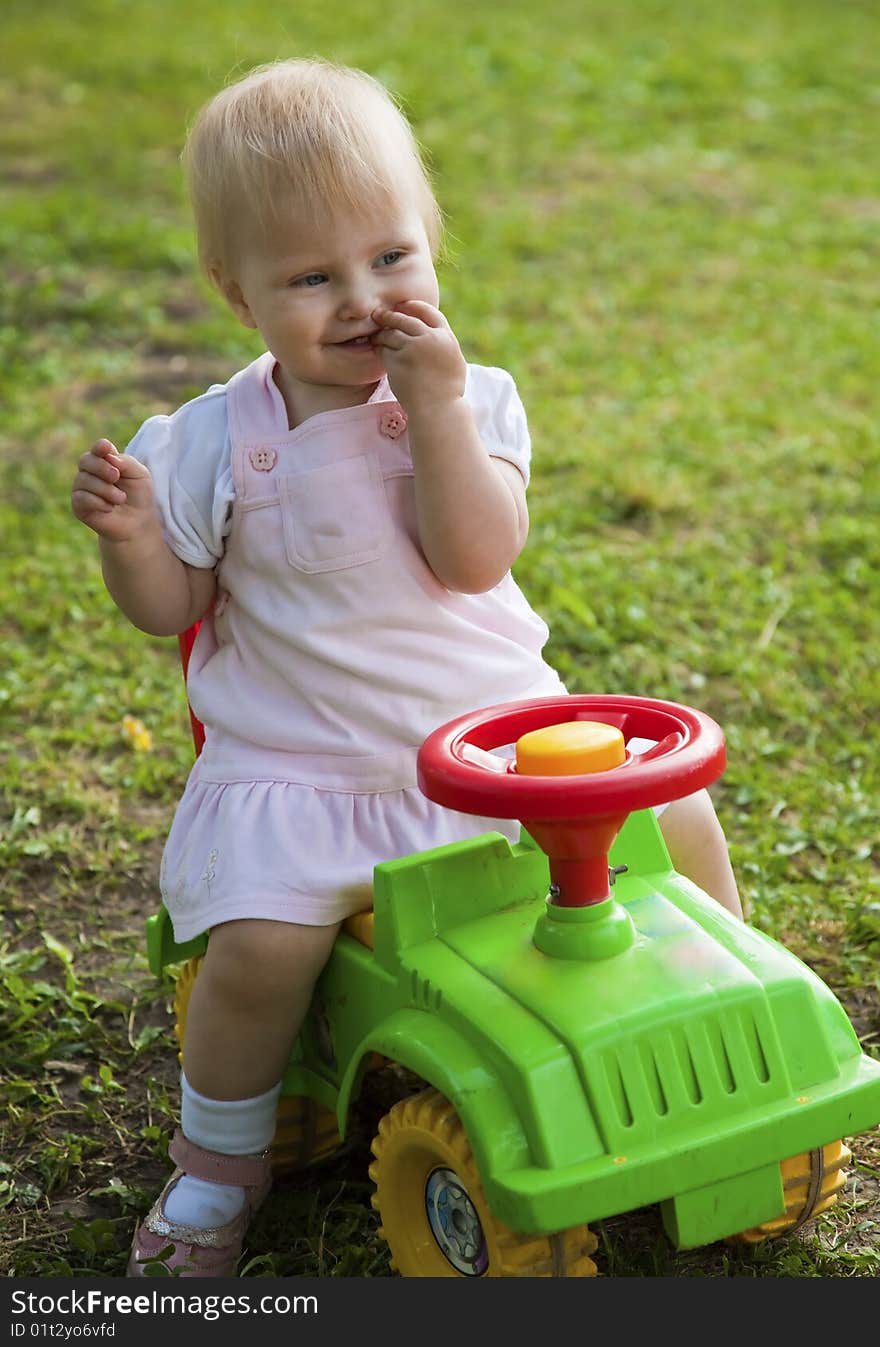 Little girl sitting on a green car