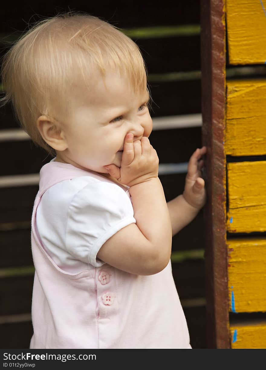 The little happy girl in rose dress. Playing in little house. The little happy girl in rose dress. Playing in little house