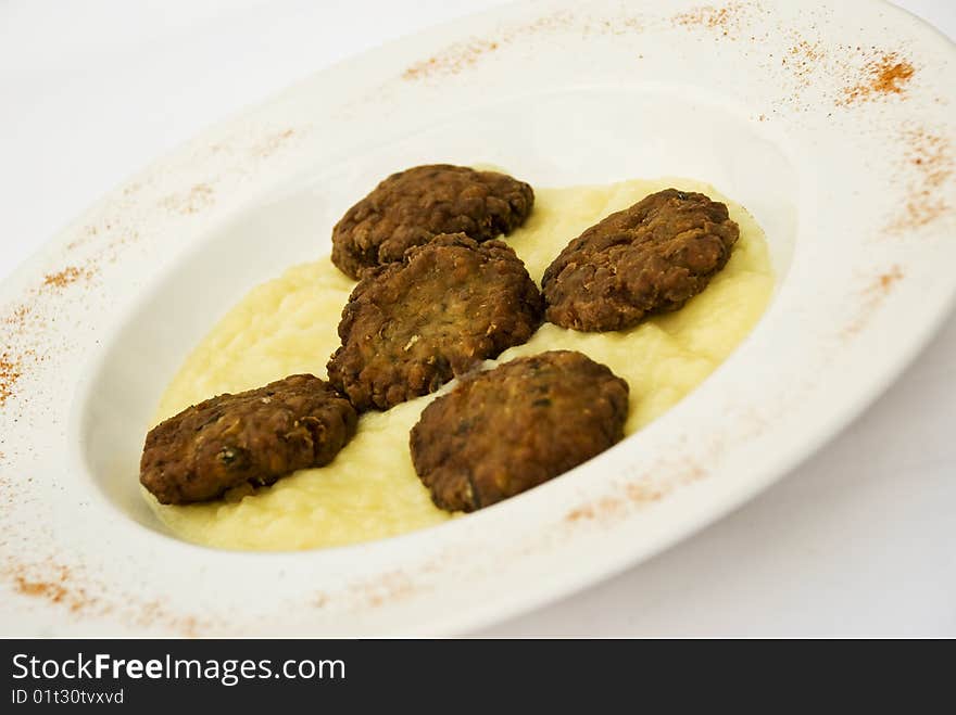 Meat ball with mashed potatoes garnish on a white plate decorated with red chili,see more in Restaurant food