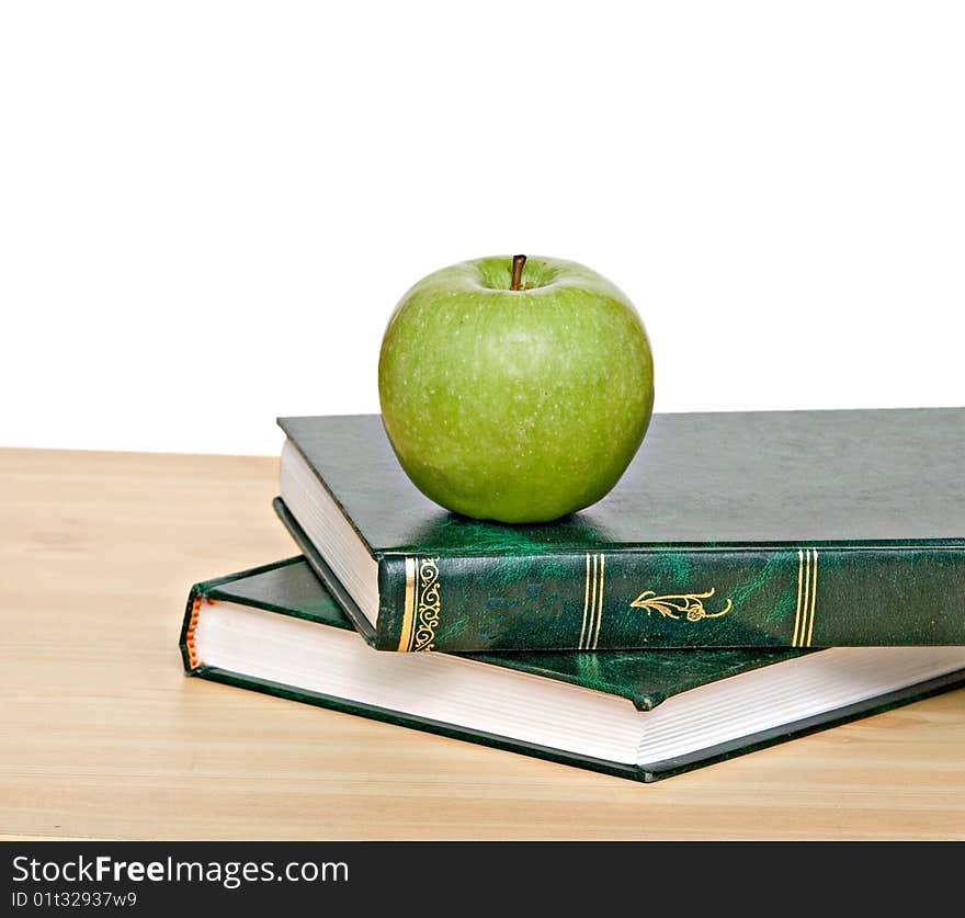 Green apple on books on desk