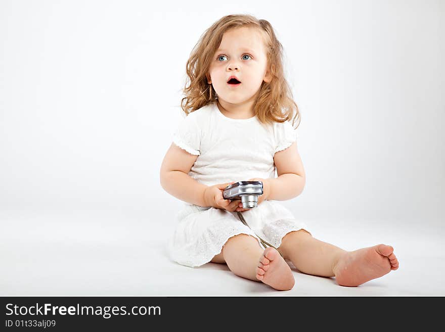 Little girl with camera on gray background