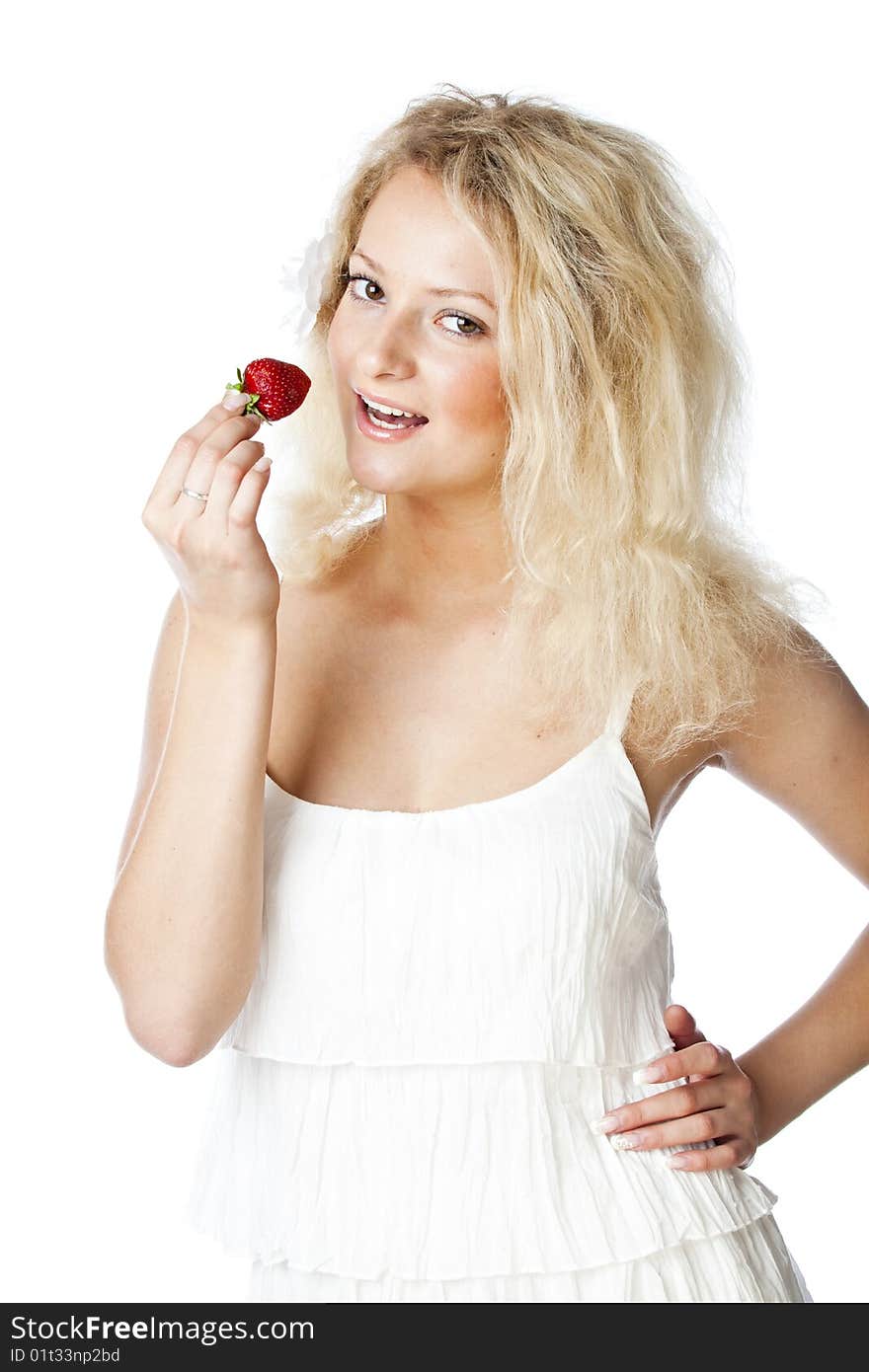 Young woman in white dress eating strawberries