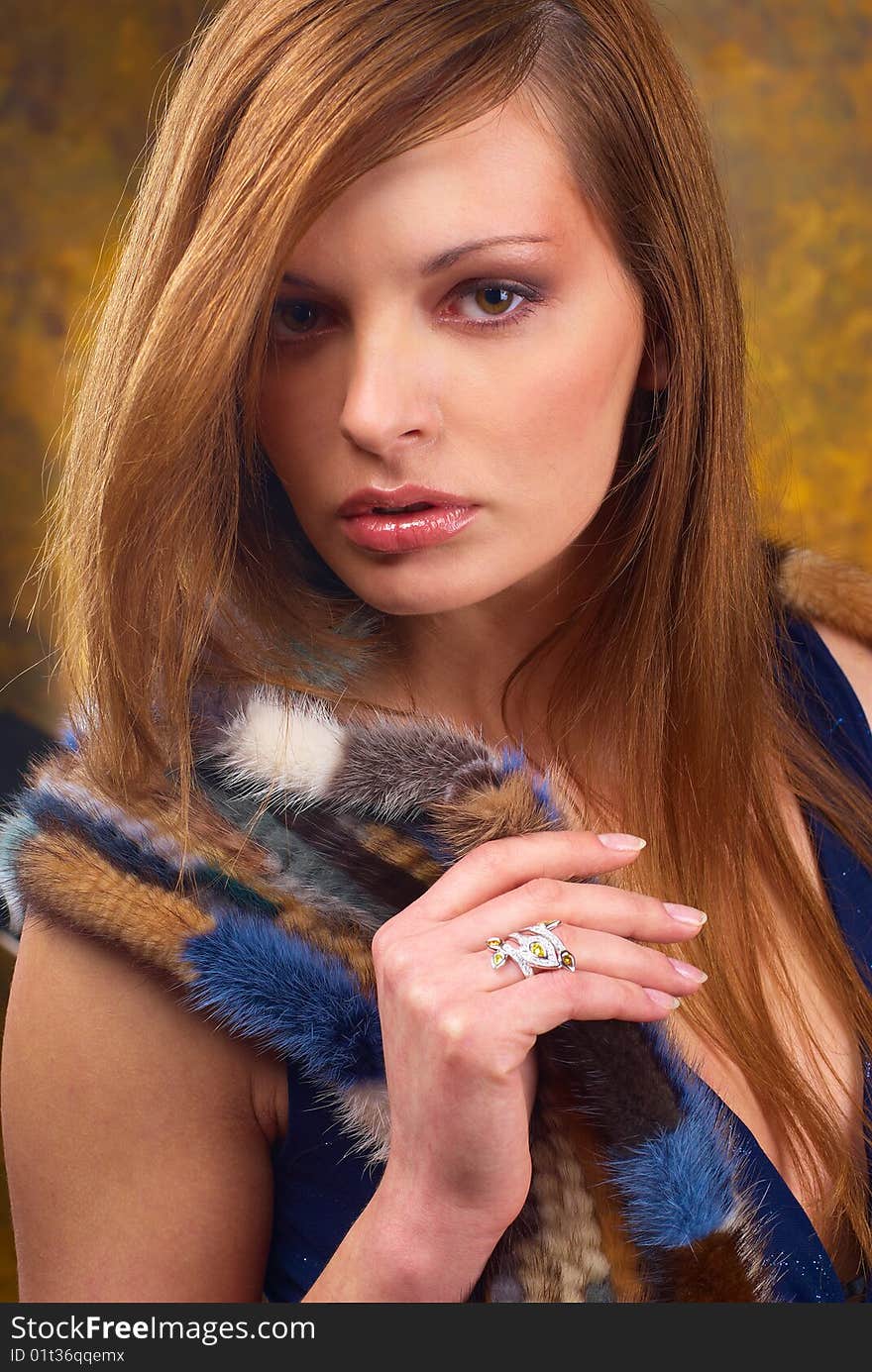 Portrait of a young beautiful brunettes, with a ring on the finger and in the fur cape blue. Portrait of a young beautiful brunettes, with a ring on the finger and in the fur cape blue