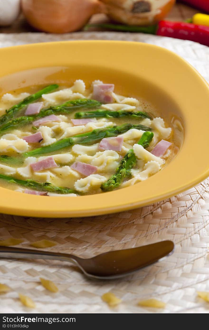 Vegetable bouillon soup with asparagus and ham