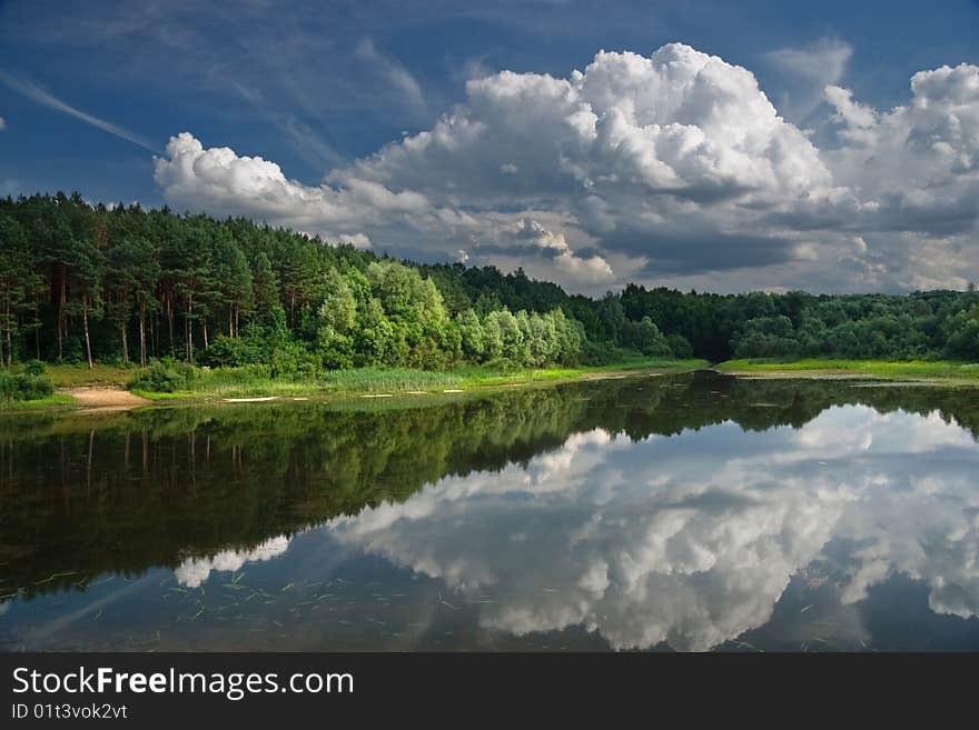 Landscape with lake on which coast a pine forest.