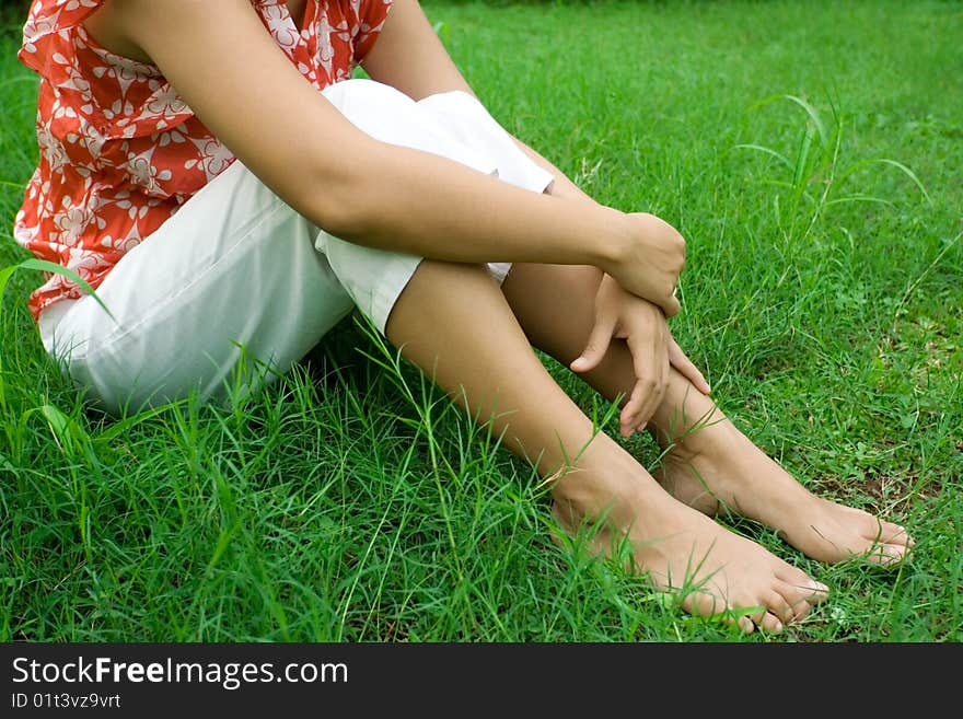 Conceptual portrait of a young asian woman sitting in the green grass, relaxing and enjoying a beautiful day outdoor. Conceptual portrait of a young asian woman sitting in the green grass, relaxing and enjoying a beautiful day outdoor