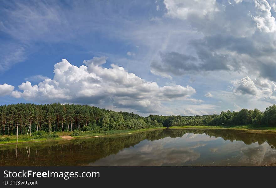 Landscape with lake on which coast a pine forest.