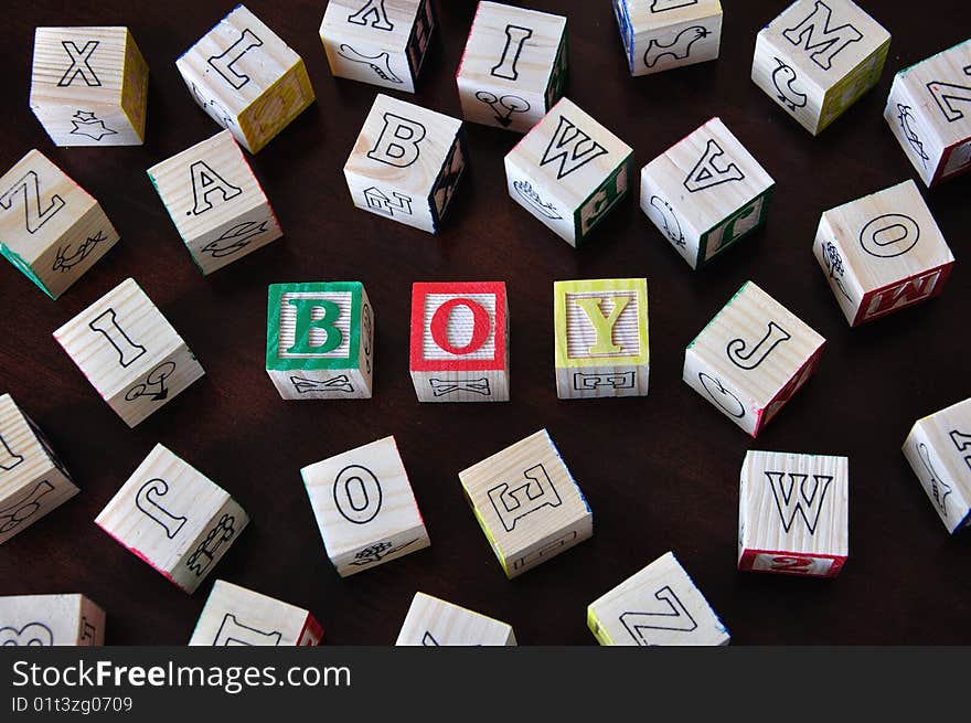 The word boy spelled out in wooden letter blocks. The word boy spelled out in wooden letter blocks