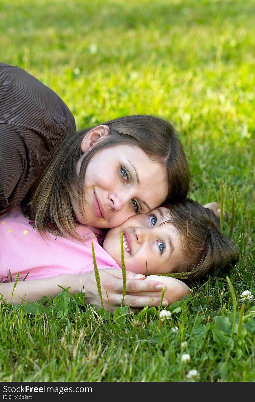 Mother and daughter lying on the grass in the park