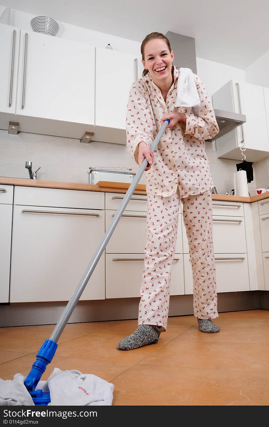 Woman In Pajamas Cleaning The Kitchen