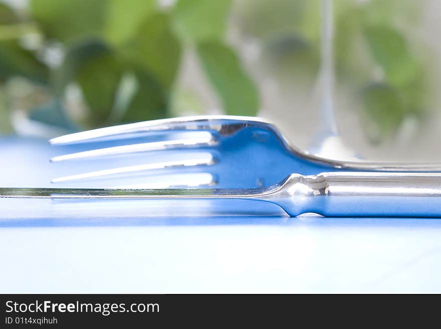 Knife and fork up close - focus is on edge of blade. Knife and fork up close - focus is on edge of blade