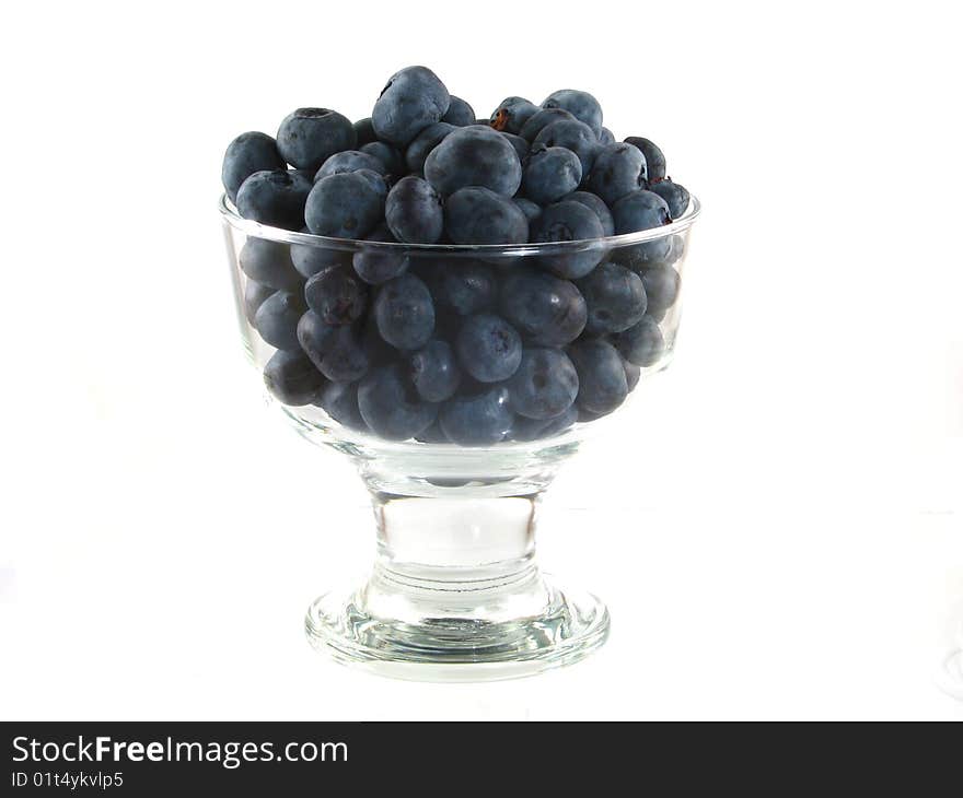 A glass bowl of fresh blueberries on a white background. A glass bowl of fresh blueberries on a white background