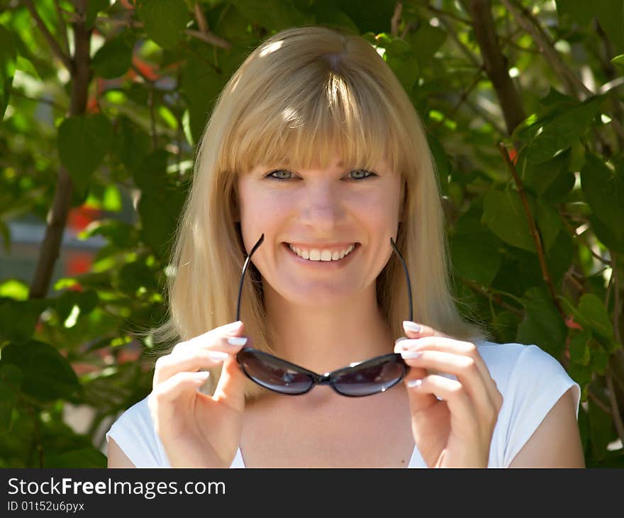 Portrait of the beautiful girl in solar glasses in the street