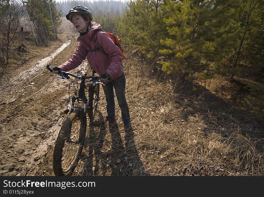 Woman-biker standing and plan pathway. Woman-biker standing and plan pathway.