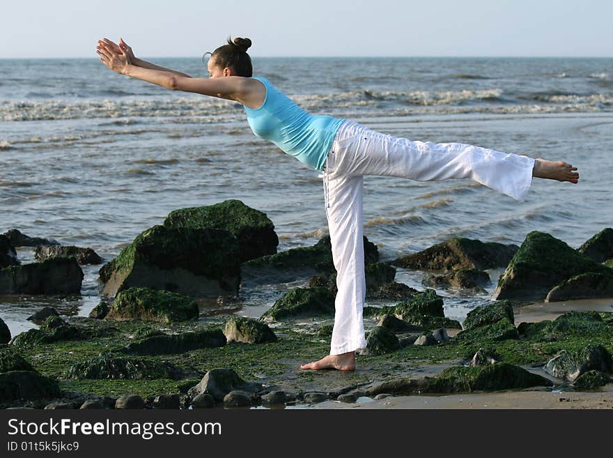 Woman doing yoga exercises at the beach. Woman doing yoga exercises at the beach