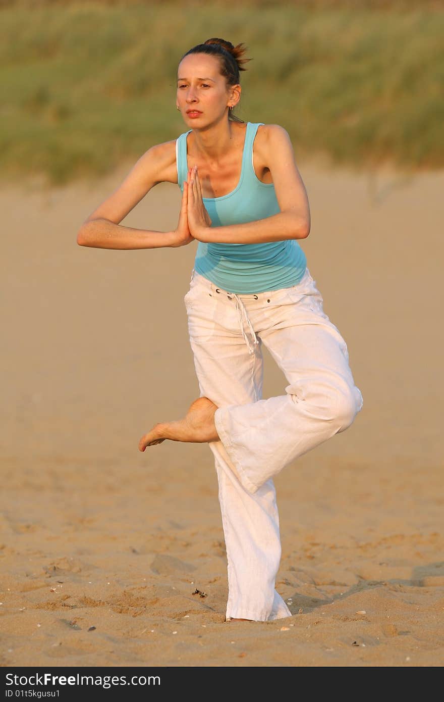 Woman doing yoga workout at the beach. Woman doing yoga workout at the beach