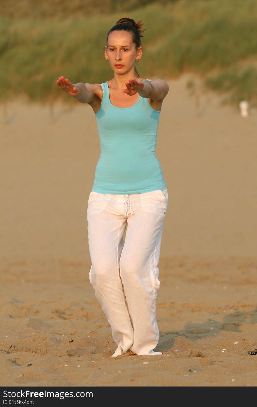 Woman doing breathing exercises at the beach