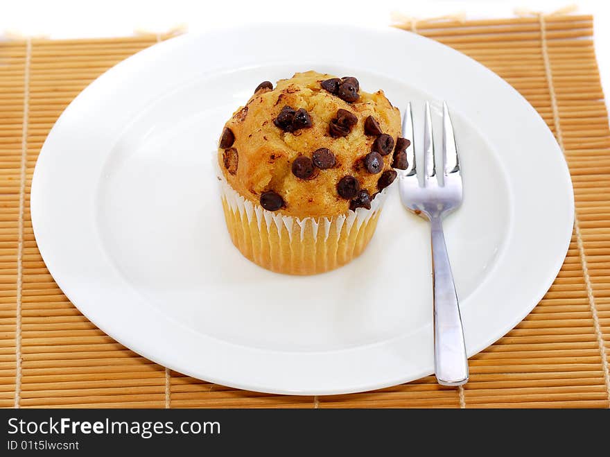 Isolated chocolate chips vanilla baked muffin. Isolated chocolate chips vanilla baked muffin