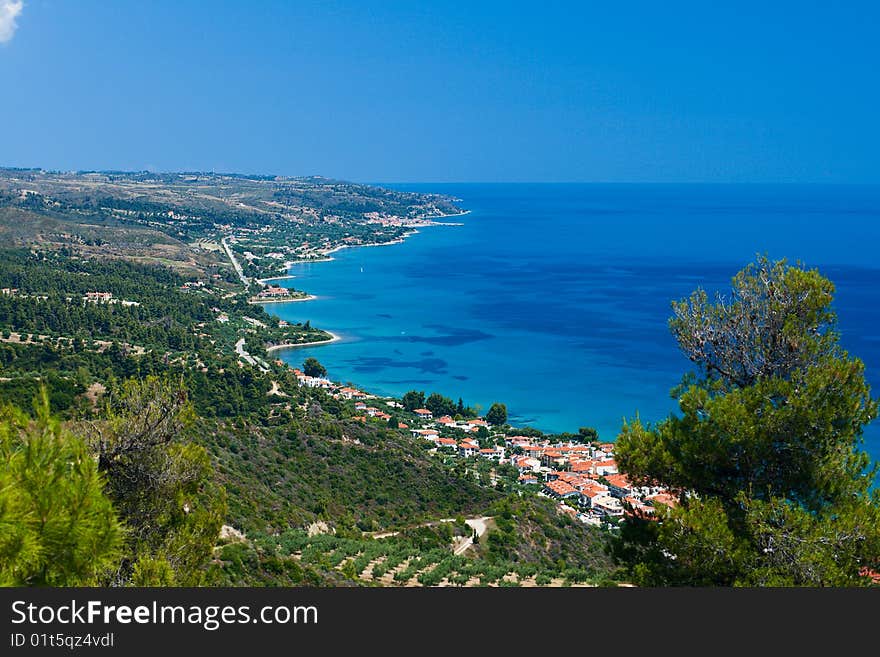 Marine landscape. Greece, Kassandra, Chalkidiki. Blue sae and sky, small towns with red roofs.