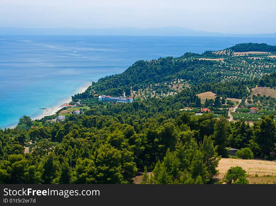 Marine landscape. Greece, Kassandra, Chalkidiki. Blue sae and sky, small town with red roofs.