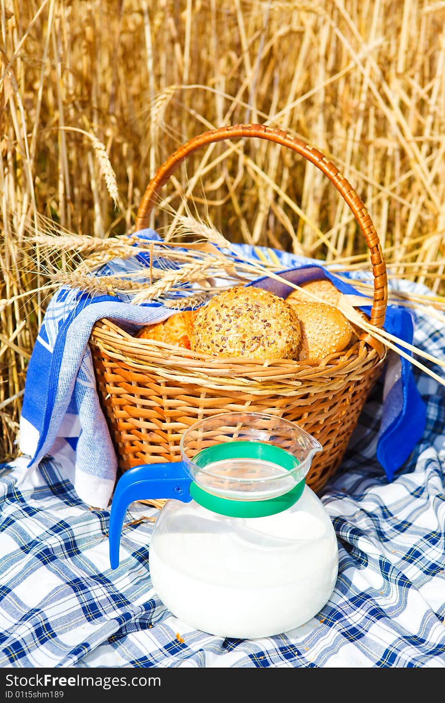 Bread in a wicker basket and milk jug. Bread in a wicker basket and milk jug