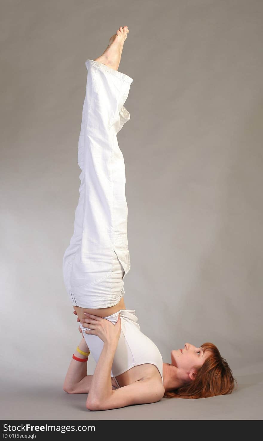 Girl practicing yoga on grey background