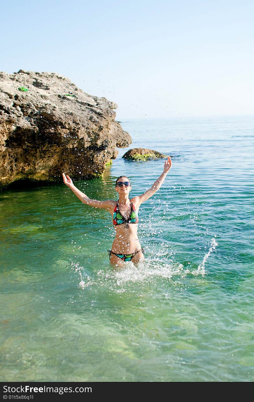 Model in beachwear playing in the water. Model in beachwear playing in the water