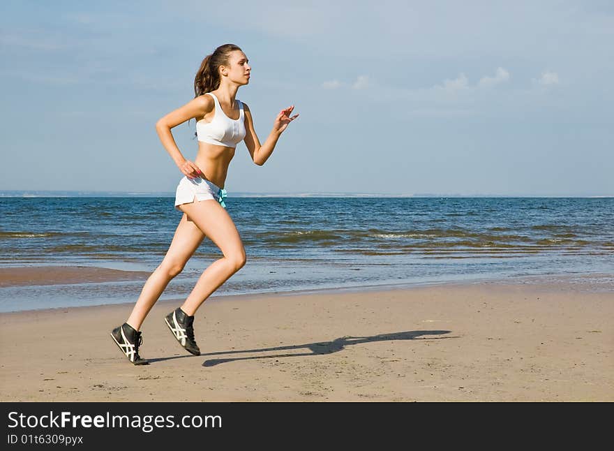 Young woman running alone on the beach