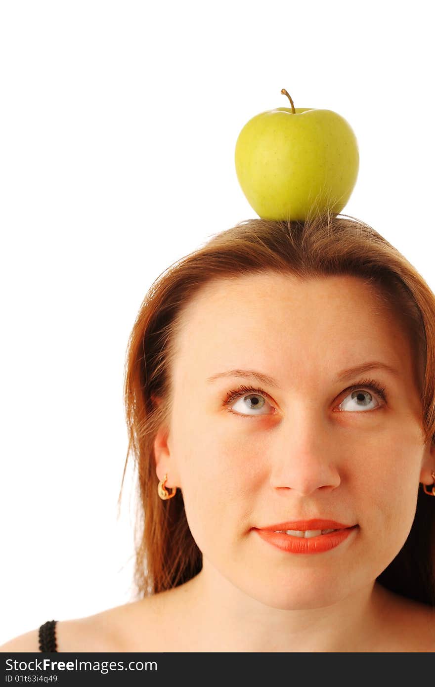 Closeup portrait of a young attractive woman with a juicy green apple on her head, looking up and smiling, isolated over white background. Closeup portrait of a young attractive woman with a juicy green apple on her head, looking up and smiling, isolated over white background