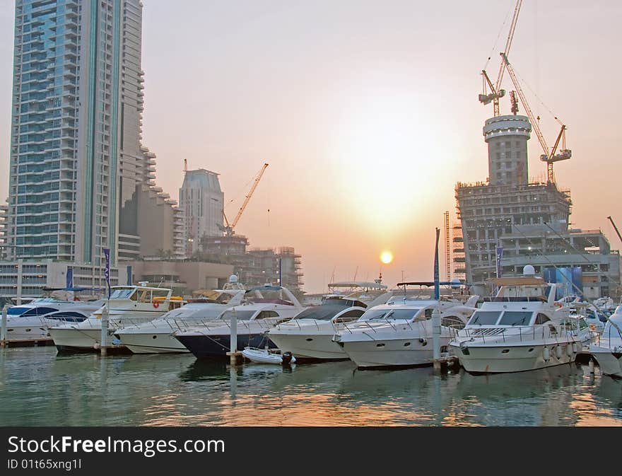 Luxury Boats berthing in Dubai Marina with buildings being built in the background. Luxury Boats berthing in Dubai Marina with buildings being built in the background