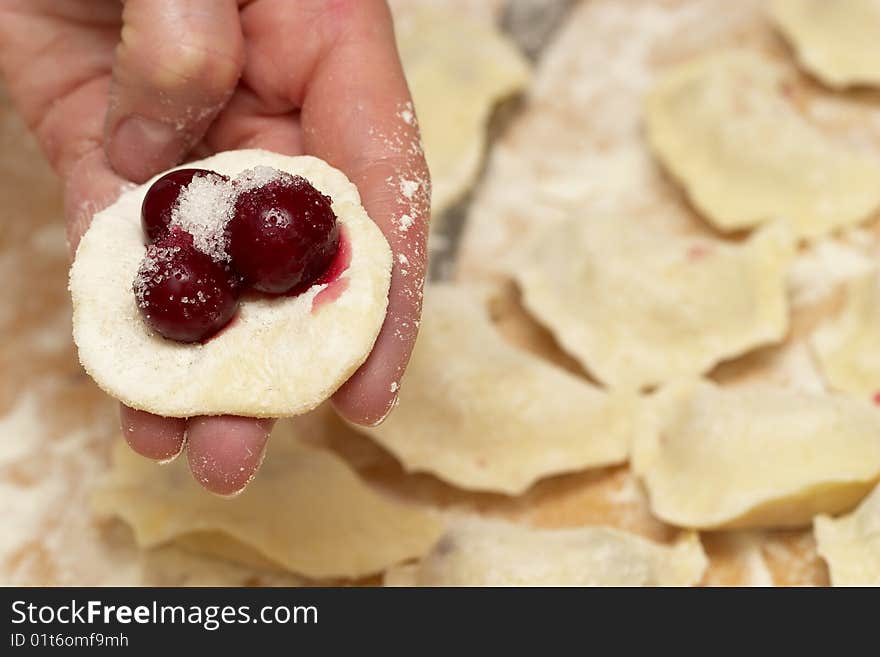 Preparing (cooking) traditional Ukrainian vareniks with cherry