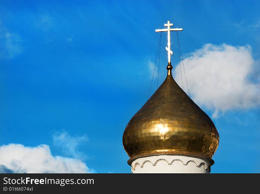 Shiny christian cross on dome of a cathedral