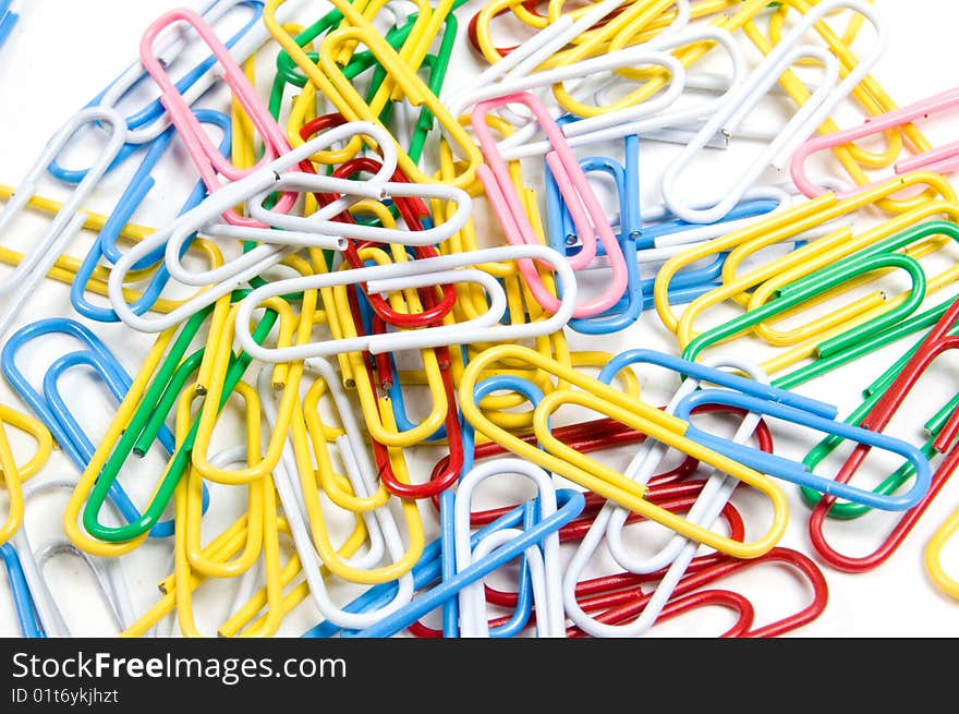 Coloured paperclips background isolated on white