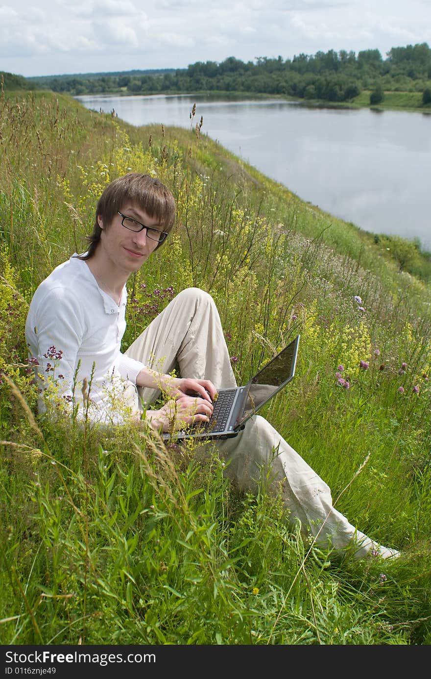 The man with laptop on green grass