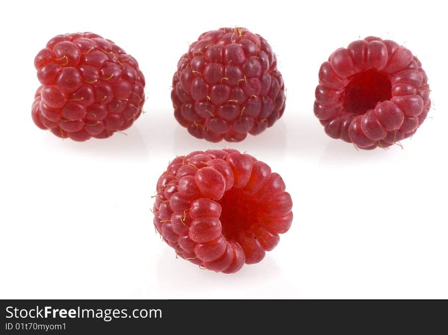 Four raspberries on white, one in the front and four in the back. Four raspberries on white, one in the front and four in the back.