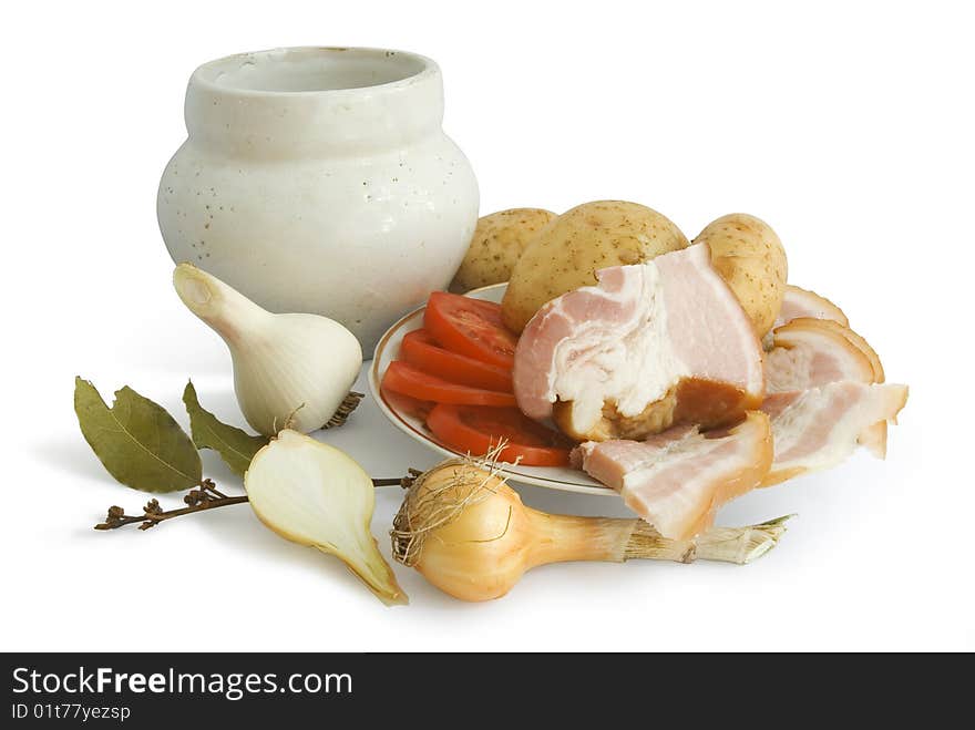 Still-life from rural products - fat, tomato slices, an onions, garlic, a bay leaf, a pot