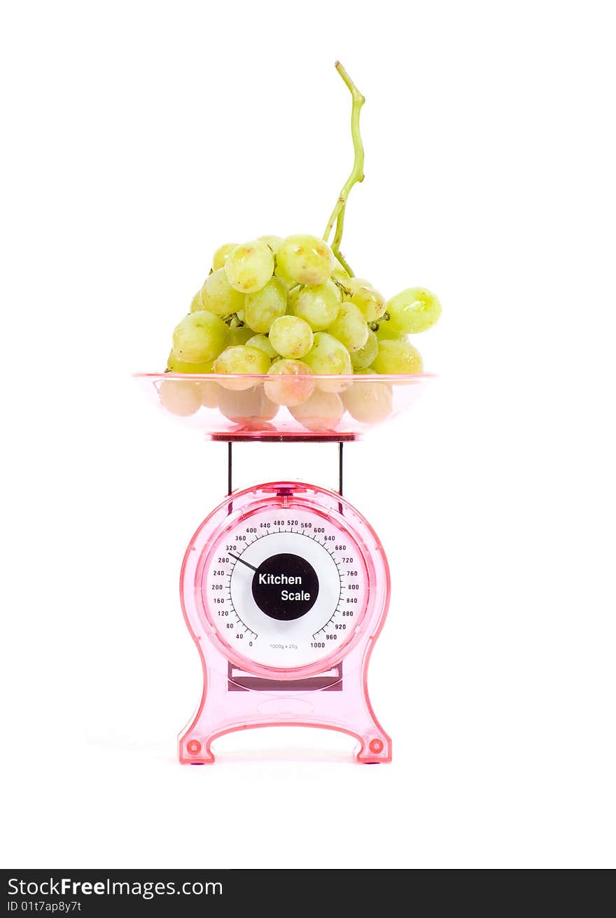 Kitchen Scales filled with green grapes isolated over white