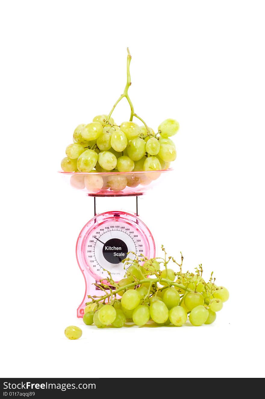 Kitchen Scales filled with green grapes isolated over white