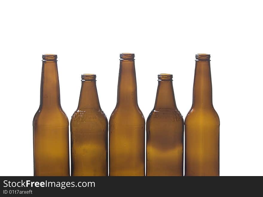 Five brown glass bottles against a white background. Five brown glass bottles against a white background.