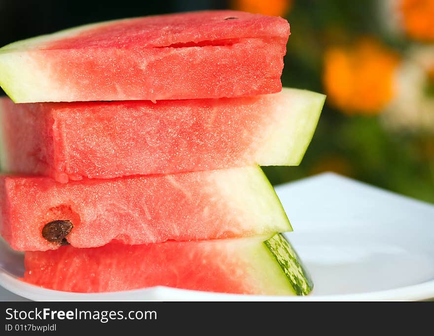 Fresh slices of watermelon on a white plate