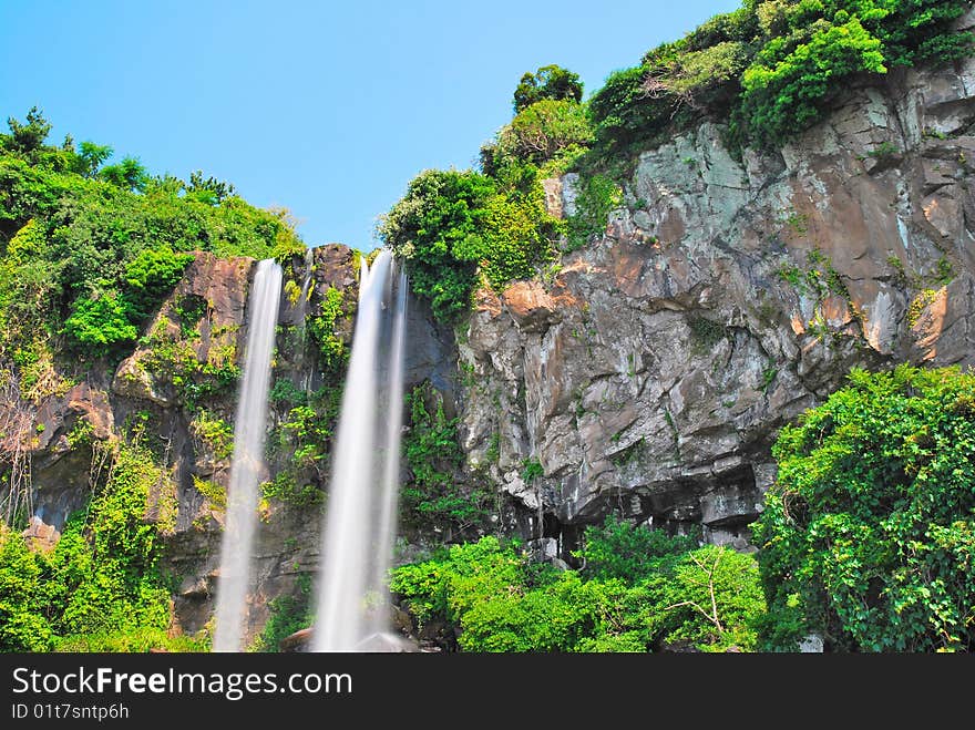 Low shot of majestic waterfall with sky background